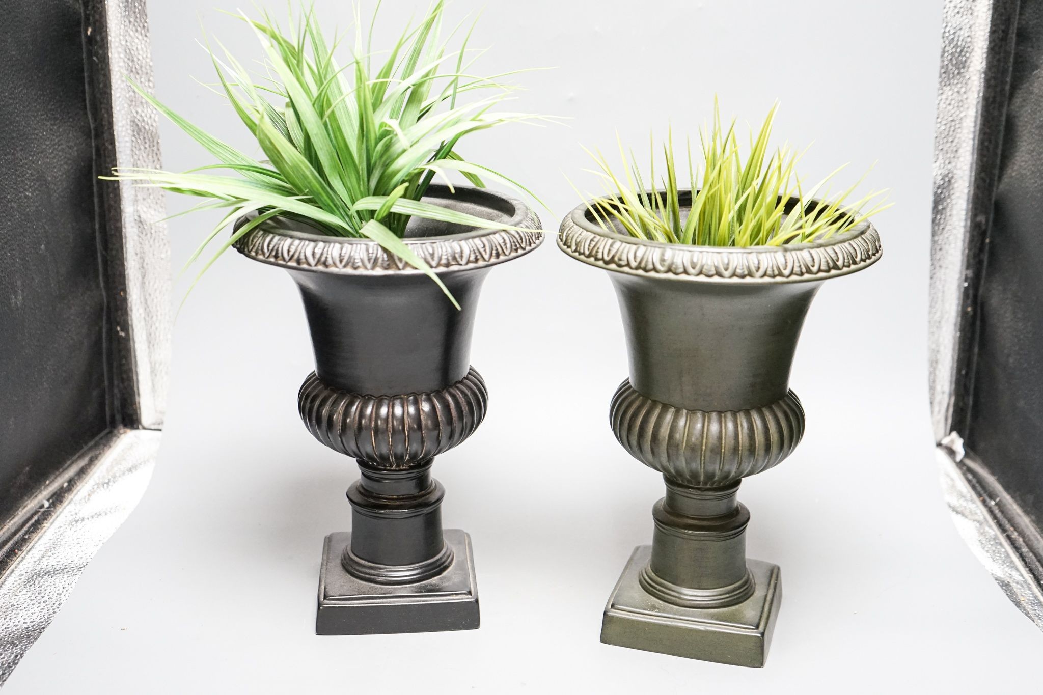 A pair of reproduction plaster urns 28cm